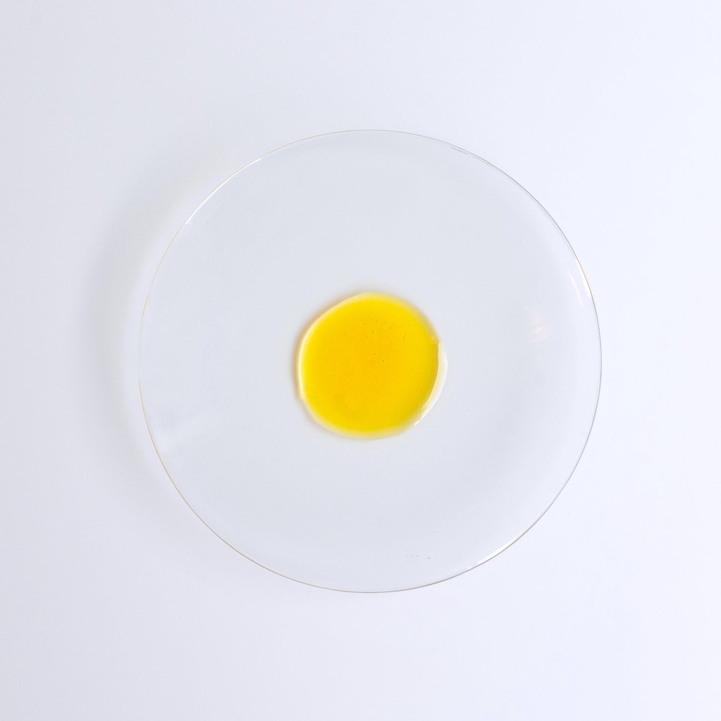 YOU ARE MY SUNSHINE Supercharged Glow Drops, bakuchiol face serum, single drop of golden liquid on a glass dish.