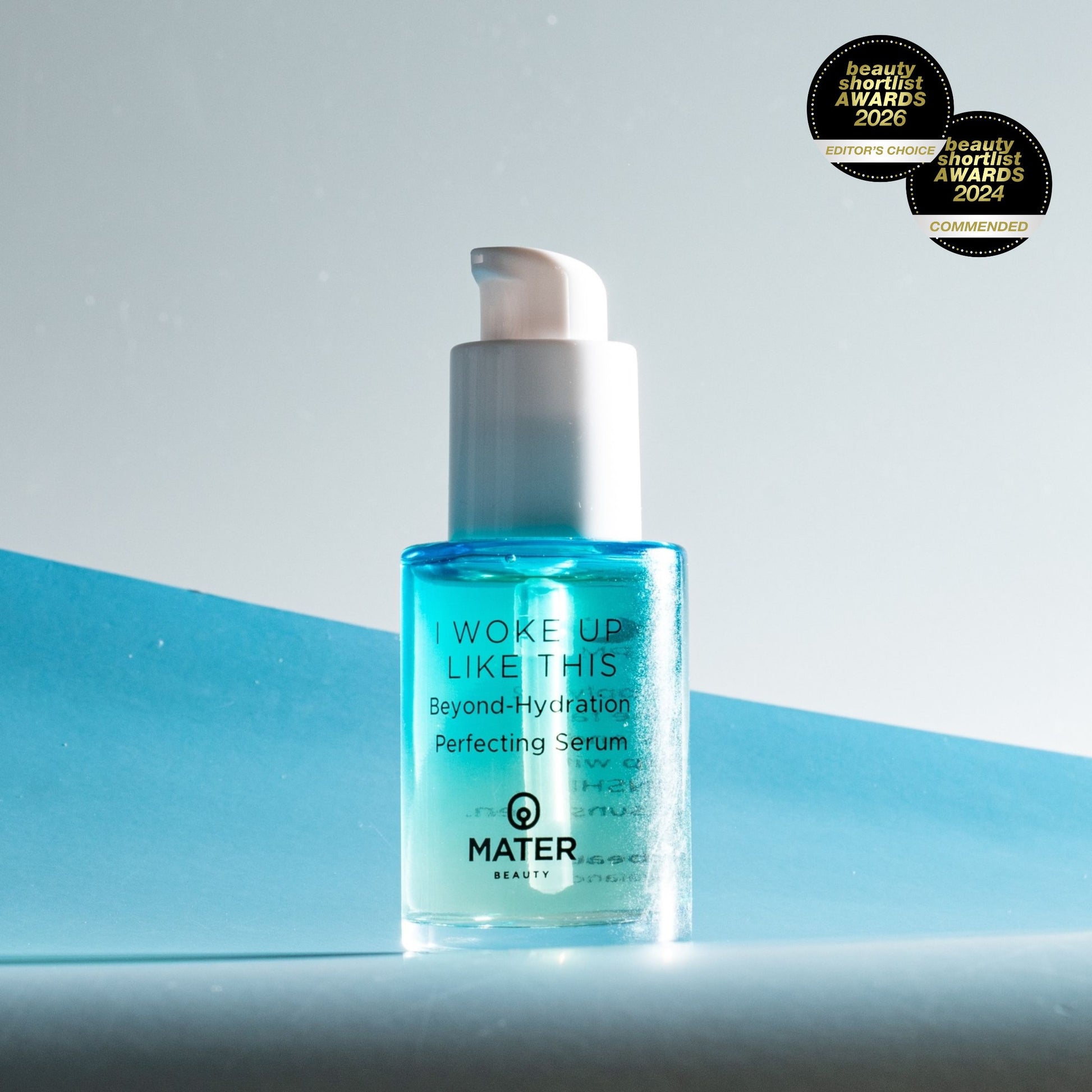 MATER Beauty I WOKE UP LIKE THIS Beyond-Hydration Perfecting Serum bottle on a black background with dramatic lighting and Beauty Shortlist Award 2006 Badges