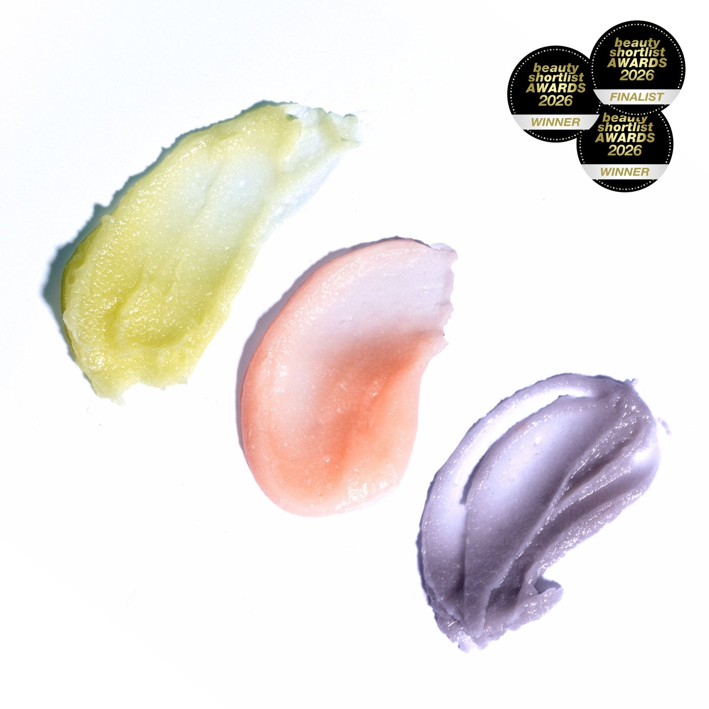 Swatches of three MATER Beauty ONE & DONE Dual-Action Cleansing Balms - Green Goddess (yellow green), Rose Above (warm gentle pink) and Force of Nature (dusky purple) on a white background