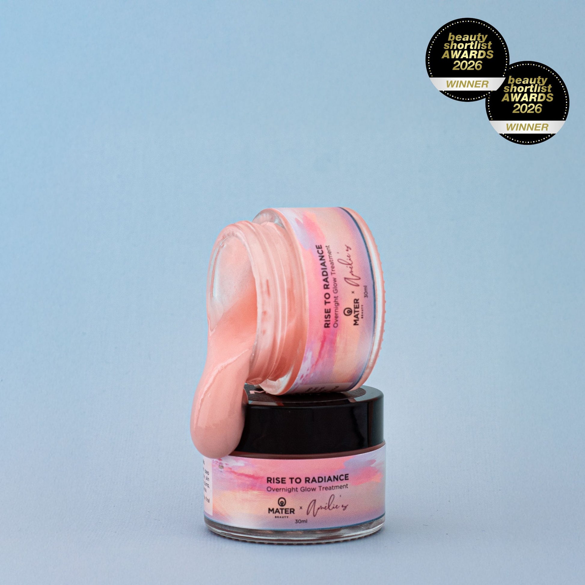 Jars of MATER Beauty Rise to Radiance Overnight Glow Treatment with pink jelly on a light blue background, featuring MATER and Amelie's branding and Beauty Shortlist Awards 2026 winner badges.