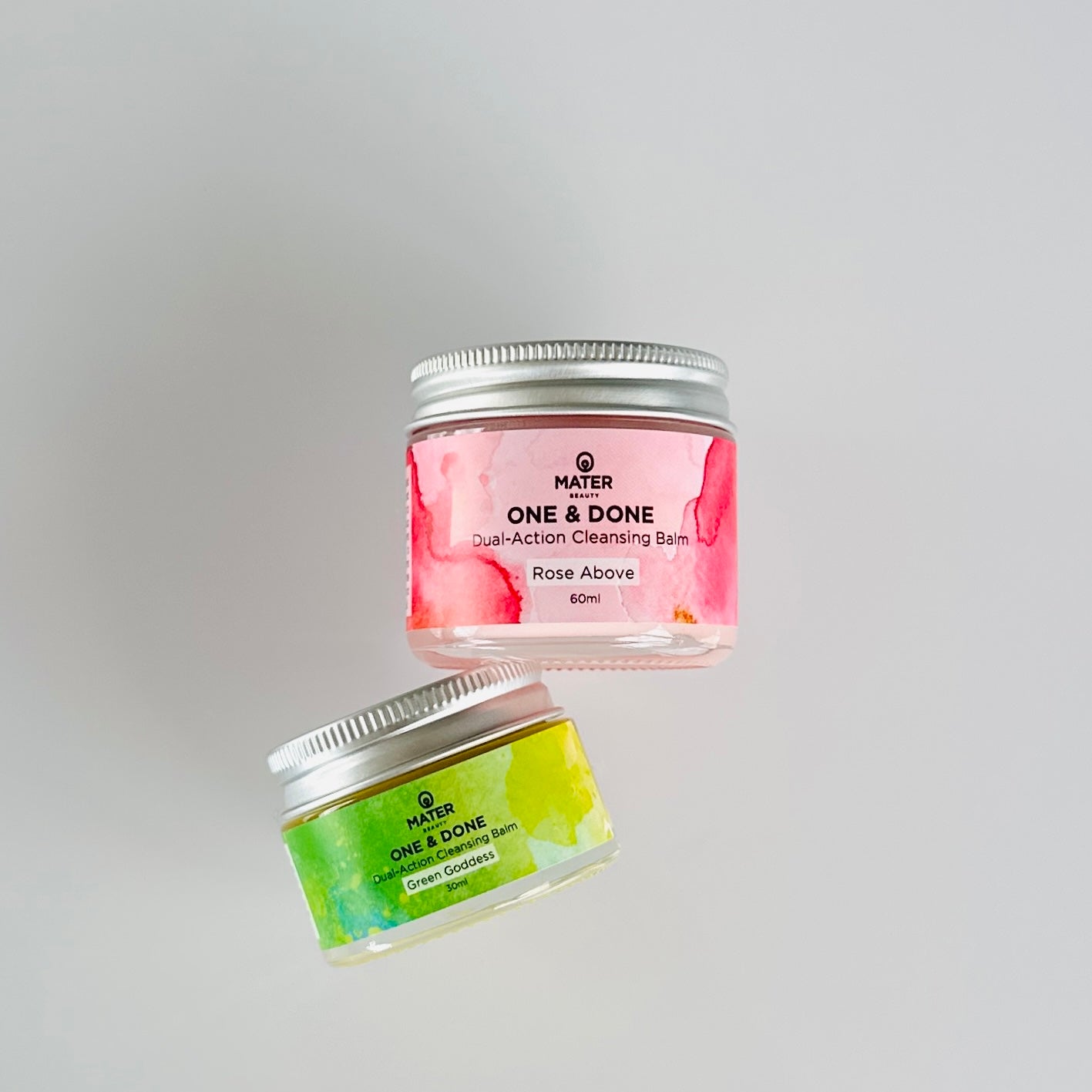 MATER Beauty ONE & DONE Dual-Action Cleansing Balm - Rose Above 60ml and Green Goddess 30ml lying flat on a white surface