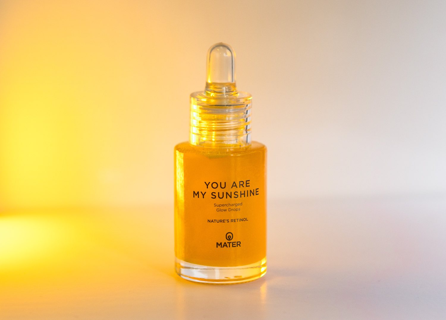 MATER Beauty YOU ARE MY SUNSHINE Supercharged Glow Drops Nature's Retinol bottle in glowing light
