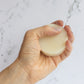 GOOD HAIR DAYS Supercharged Conditioner Bar for dry or damaged hair. Round pale yellow puck wet in hand.